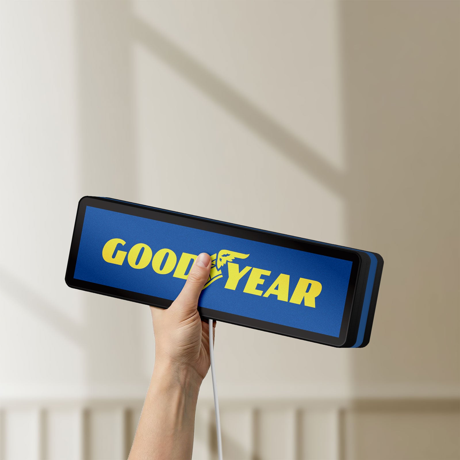 Unlit Goodyear LED lightbox held by hand to show size and details