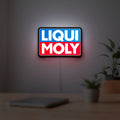 Liqui Moly LED lightbox hanging on a room wall with soft red light