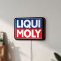 Unlit Liqui Moly LED lightbox mounted on a wall in daylight