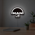 MAN Trucks LED lightbox hanging on a room wall with soft white light