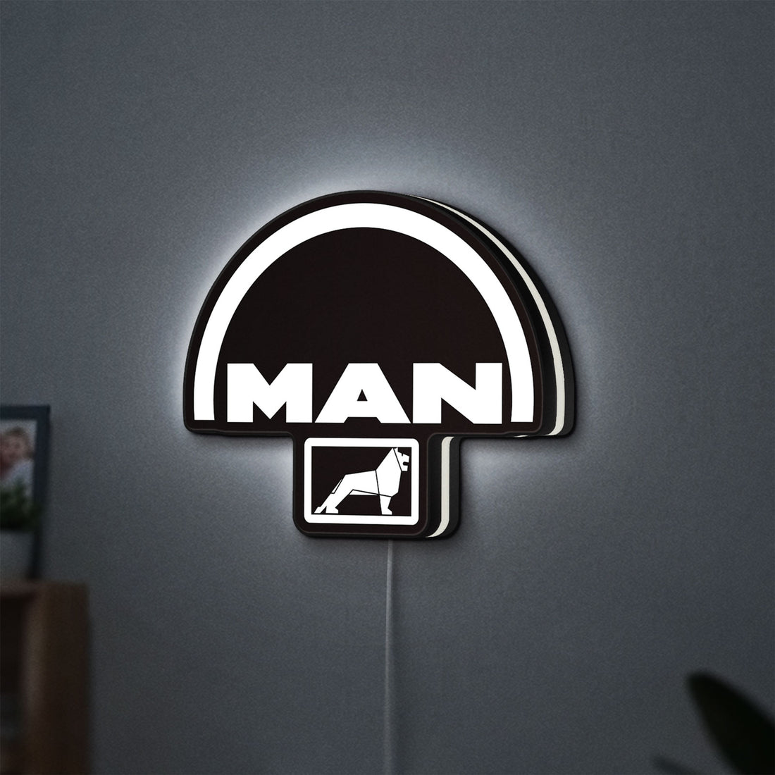 MAN Trucks LED lightbox hanging on a wall with white glow