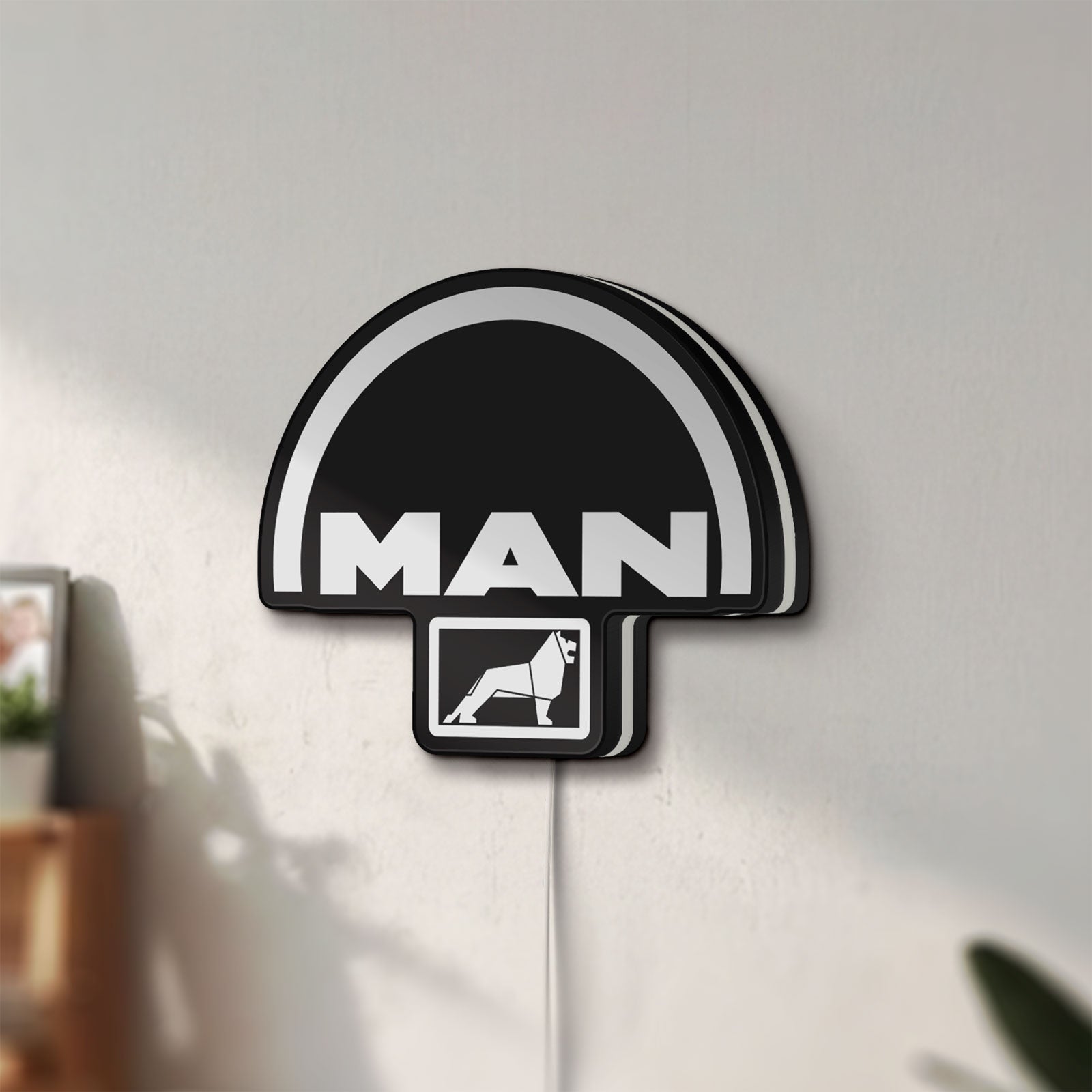 Unlit MAN Trucks LED lightbox mounted on a wall in daylight
