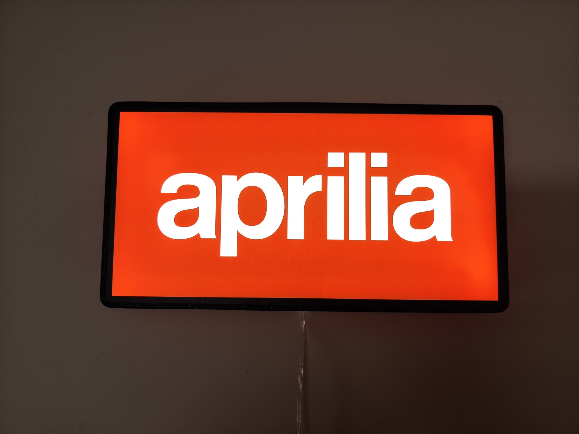 Aprilia Dimmable LED Sign (30cm) - Illuminated flat lay front view, unique wall art for desk and room decor
