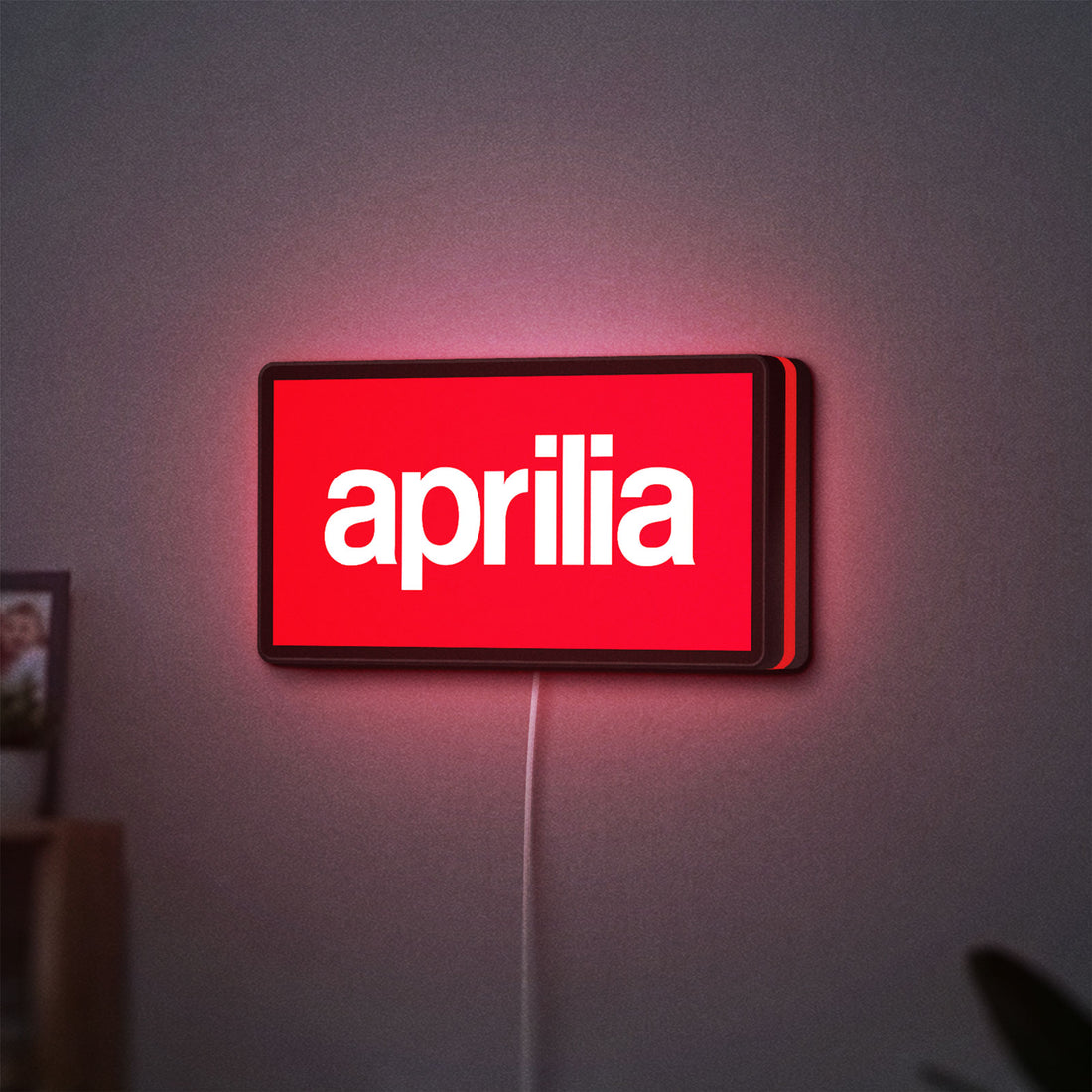 Aprilia LED lightbox hanging on a wall with red glow