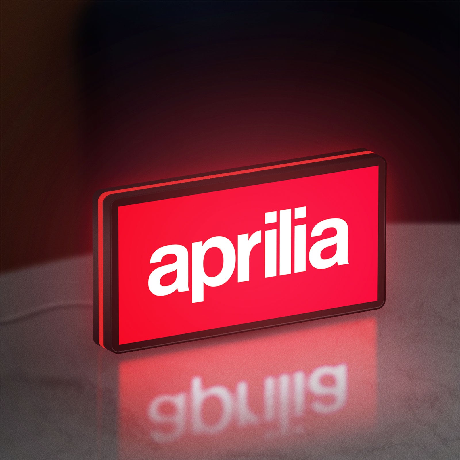 Aprilia LED lightbox standing on a desk from an angled side view with red glow