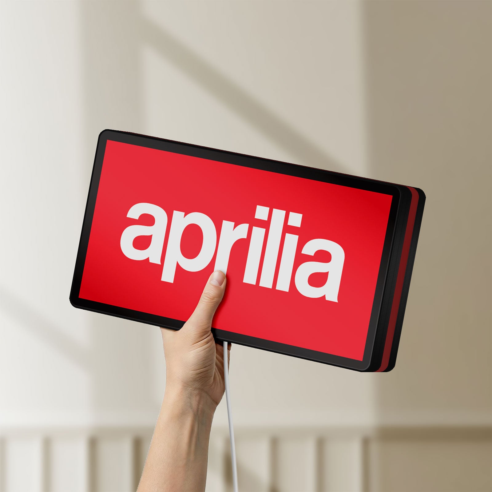 Unlit Aprilia LED lightbox held by hand to show size and details