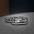 Gas Monkey Garage LED lightbox lying flat on a desk with white glow