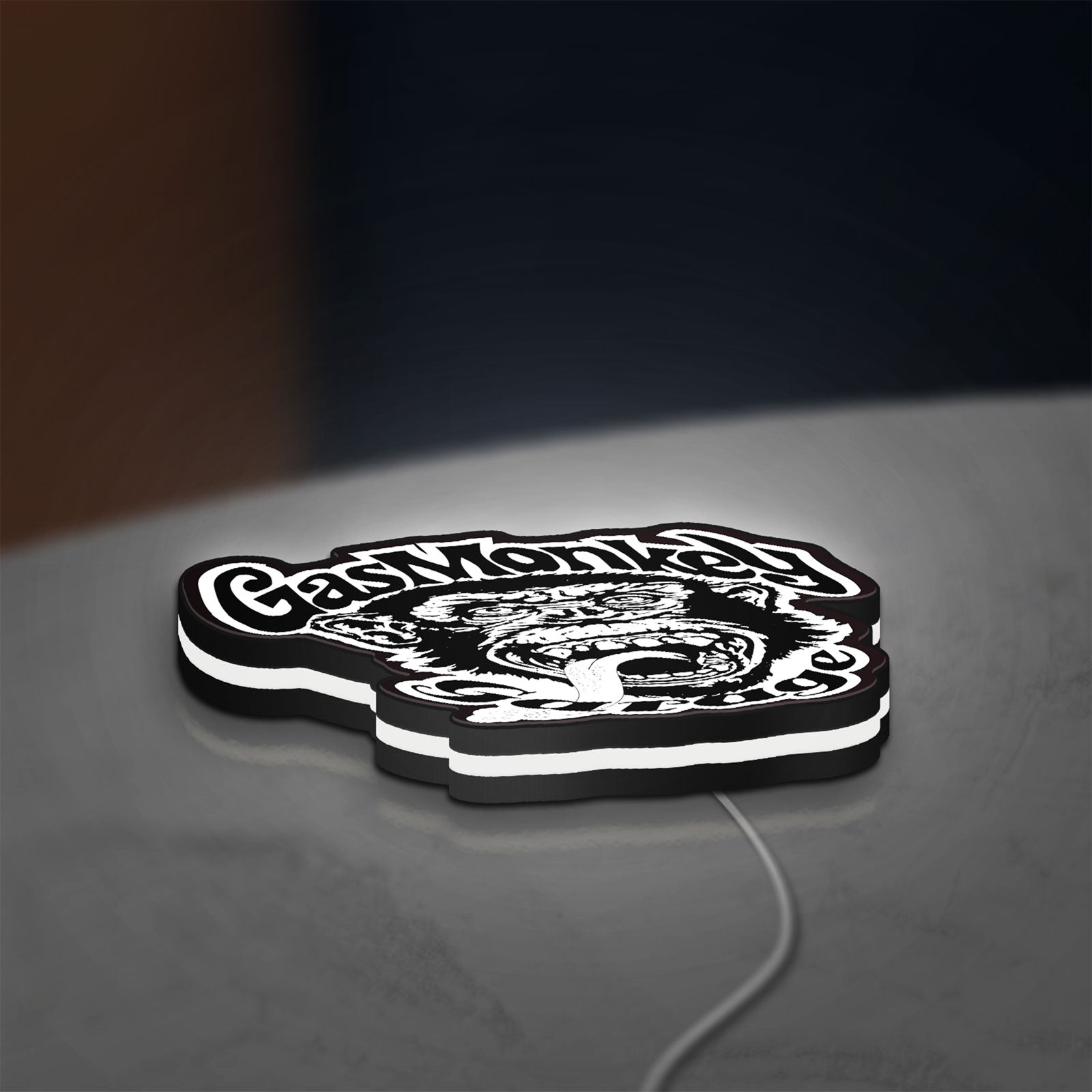 Gas Monkey Garage LED lightbox lying flat on a desk with white glow