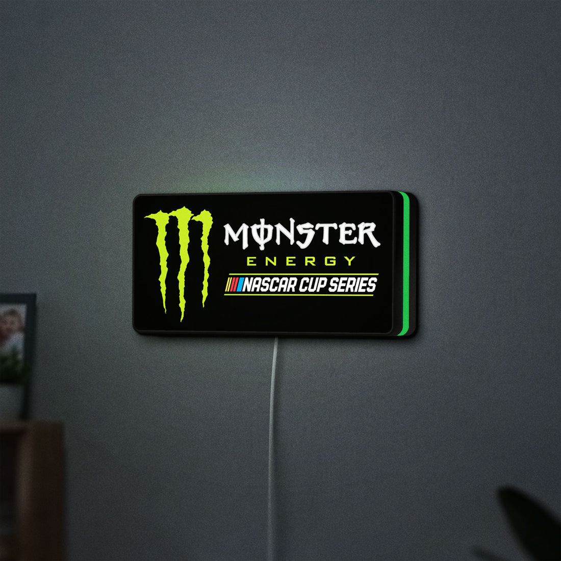Monster Energy NASCAR Cup Series LED lightbox hanging on a wall with green glow