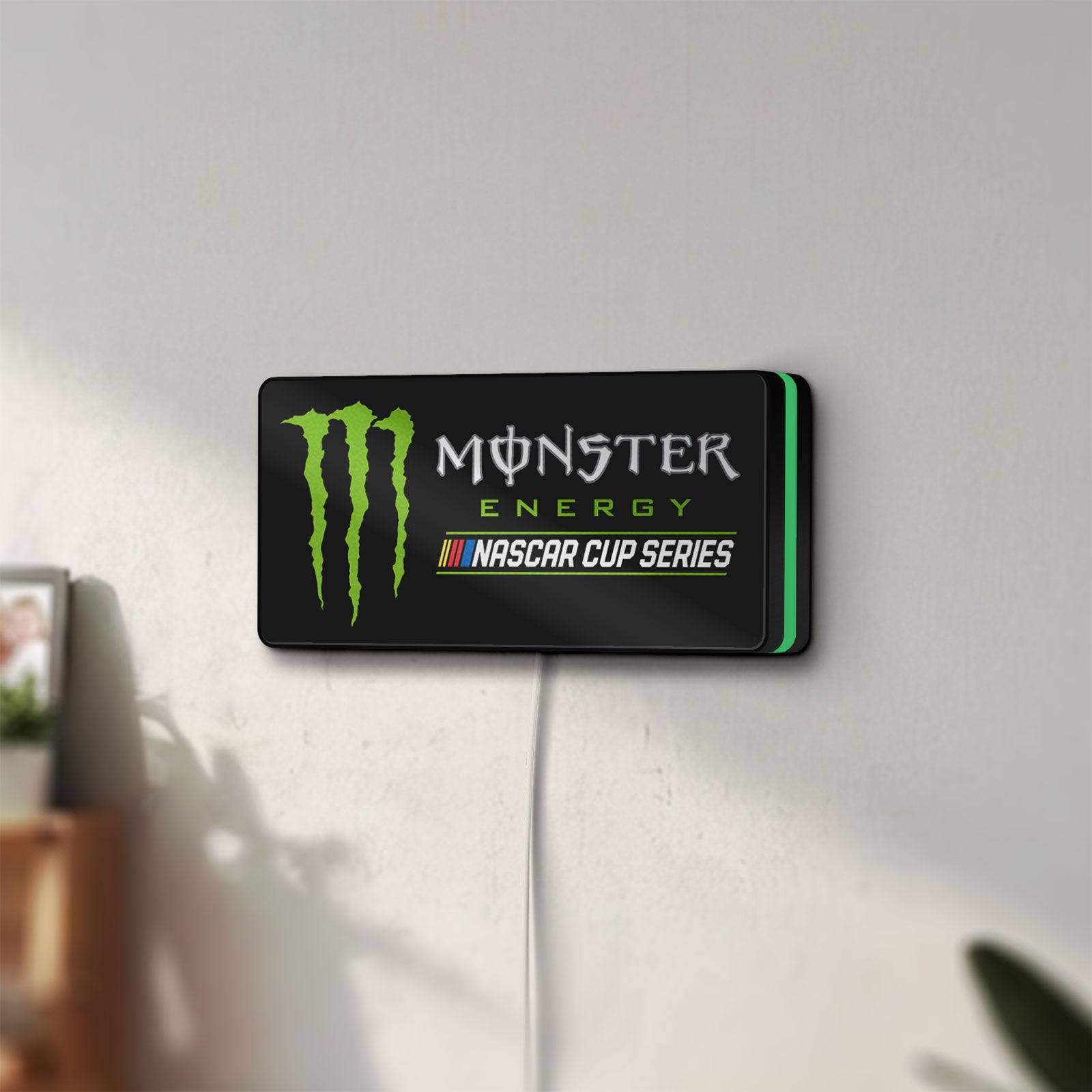 Unlit Monster Energy NASCAR Cup Series LED lightbox mounted on a wall in daylight