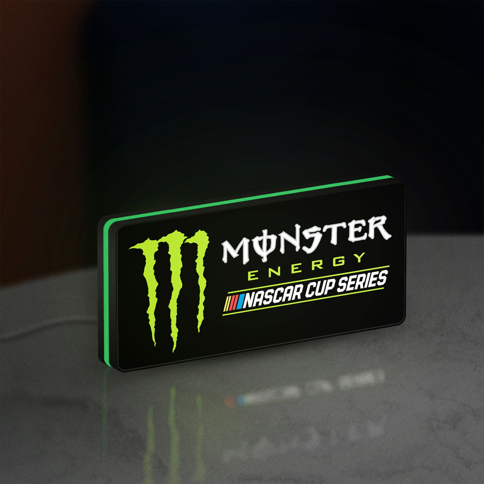 Monster Energy NASCAR Cup Series LED lightbox standing on a desk from an angled side view with green glow