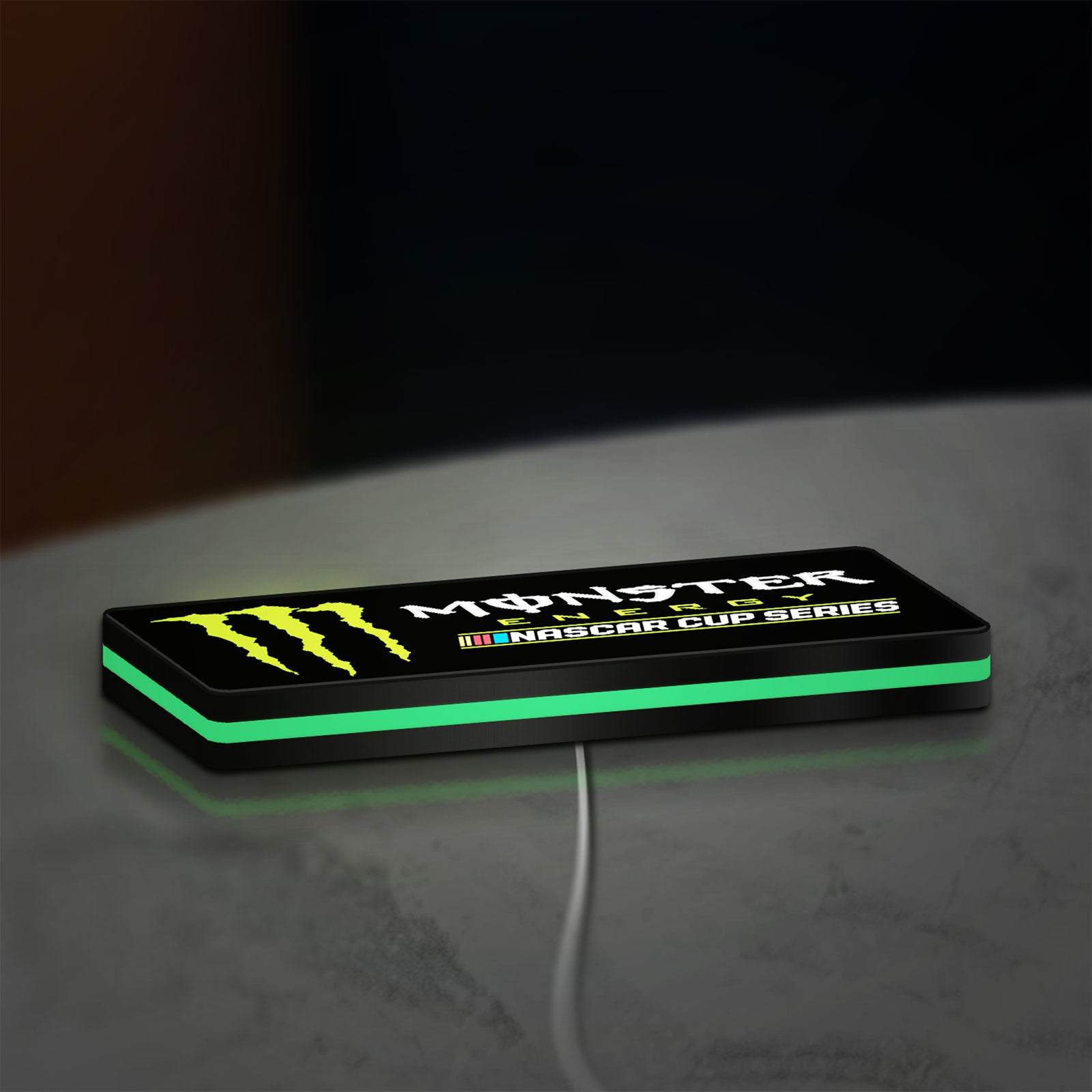 Monster Energy NASCAR Cup Series LED lightbox lying flat on a desk with green glow