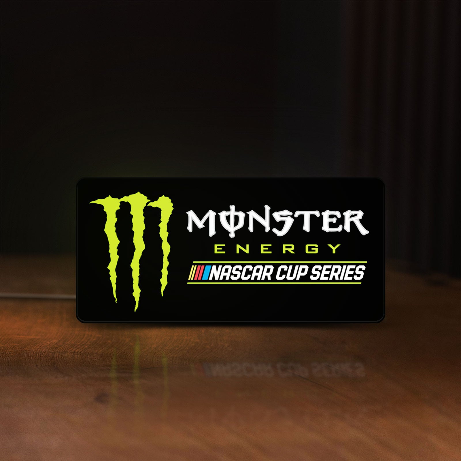 Front view of Monster Energy NASCAR Cup Series LED lightbox sign glowing on a wooden desk