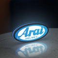 Arai Helmet LED lightbox standing on a desk from an angled side view with blue glow