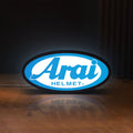 Front view of Arai Helmet LED lightbox sign glowing on a wooden desk