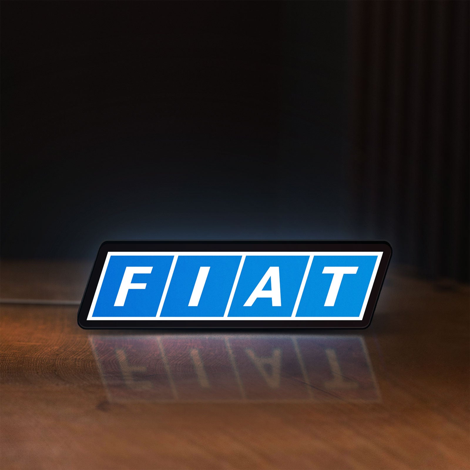 Front view of Fiat LED lightbox sign glowing on a wooden desk
