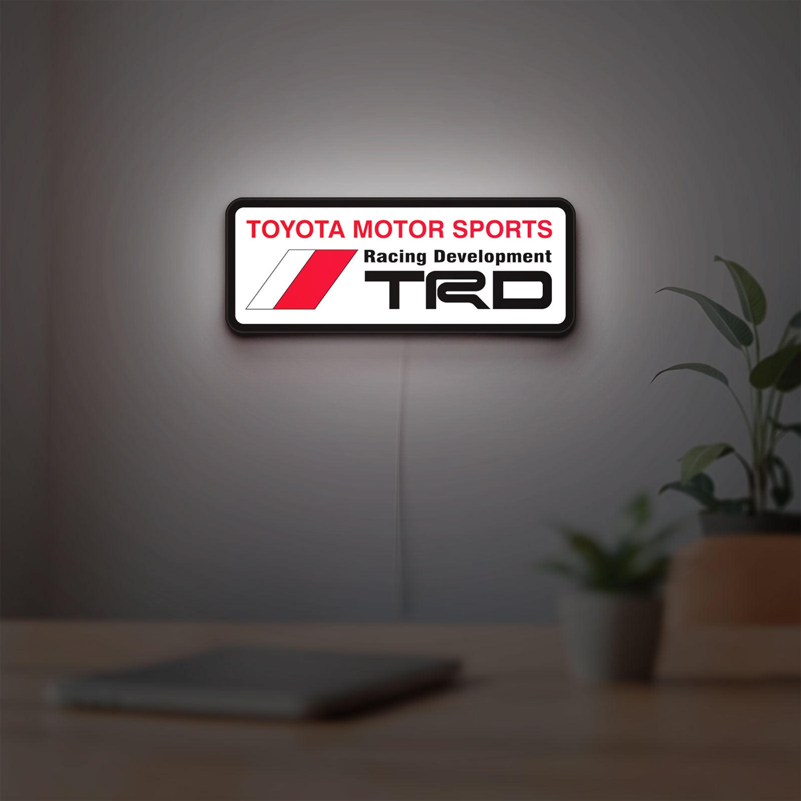 TRD LED lightbox hanging on a room wall with soft white light