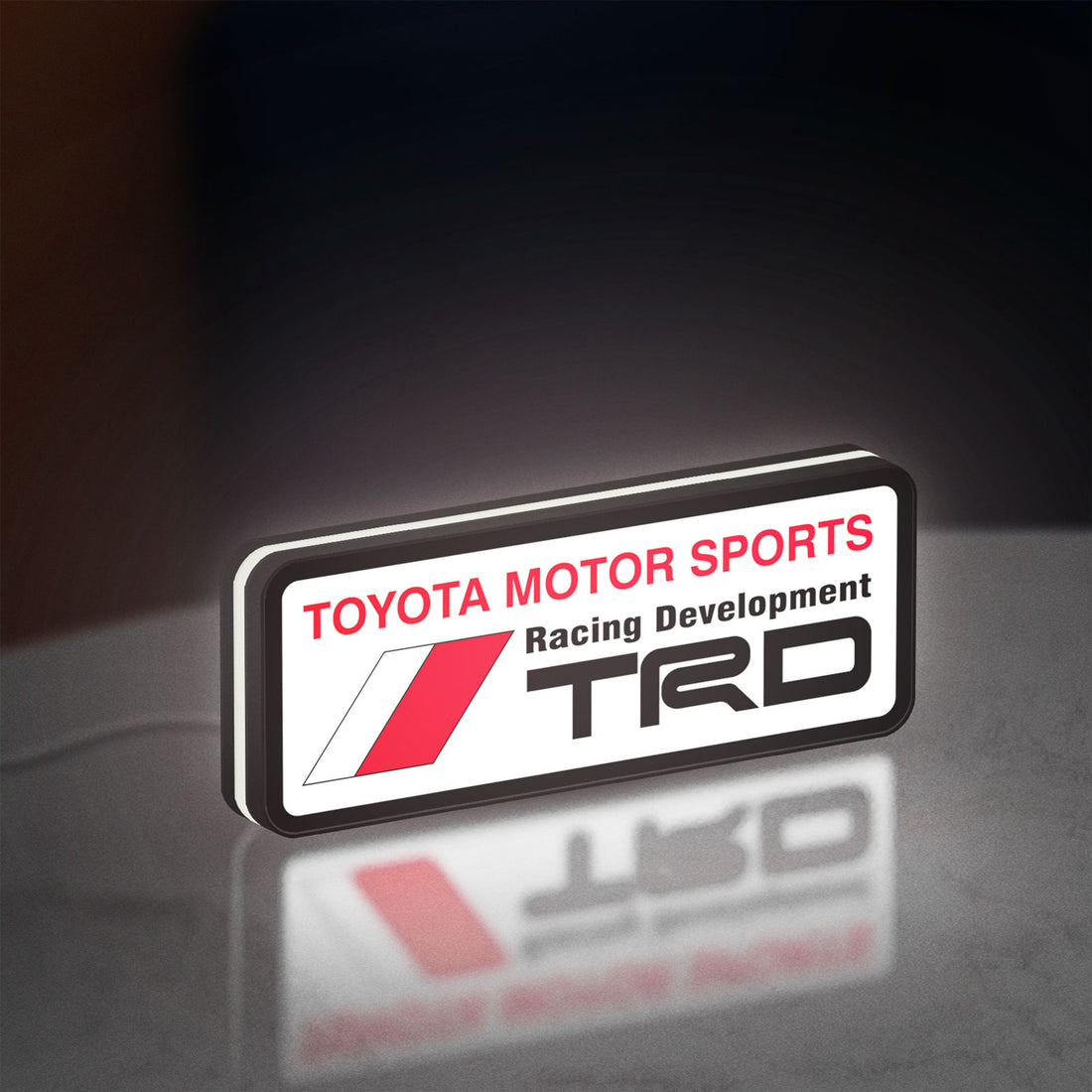 TRD LED lightbox hanging on a wall with white glow