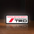 Front view of TRD LED lightbox sign glowing on a wooden desk