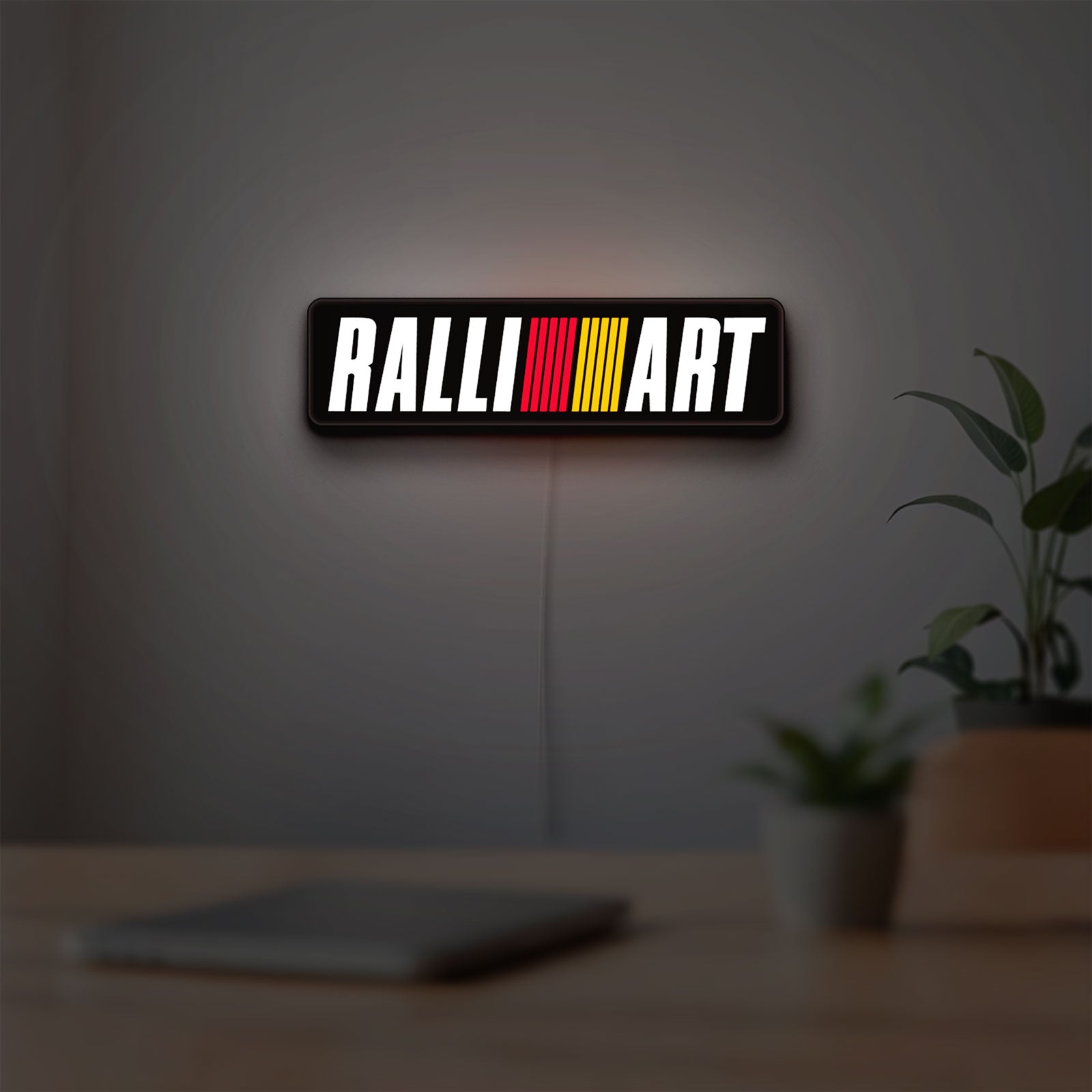 Ralliart LED lightbox hanging on a room wall with soft white light