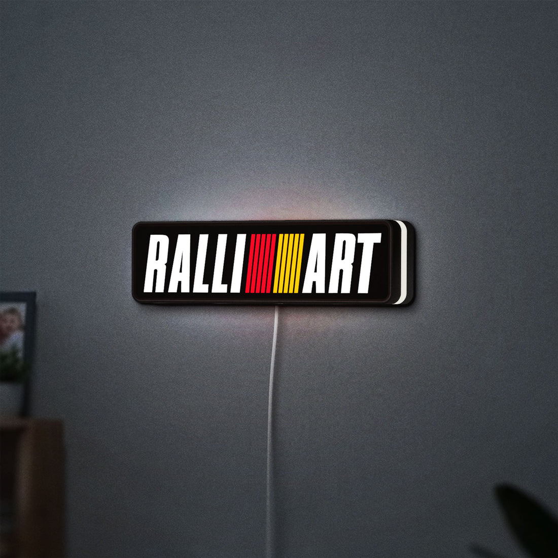 Ralliart LED lightbox hanging on a wall with white glow