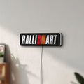 Unlit Ralliart LED lightbox mounted on a wall in daylight