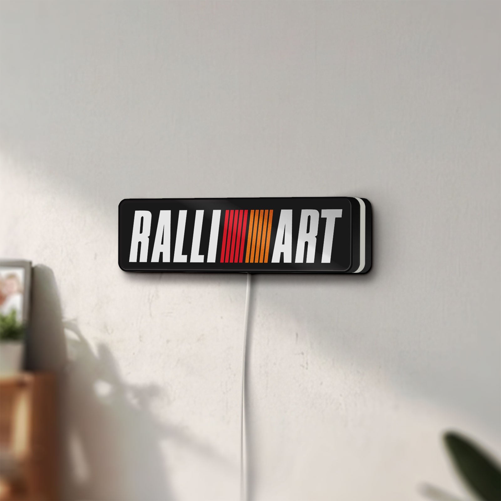 Unlit Ralliart LED lightbox mounted on a wall in daylight
