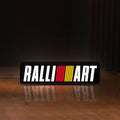 Front view of Ralliart LED lightbox sign glowing on a wooden desk