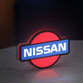 Nissan LED lightbox standing on a desk from an angled side view with red glow