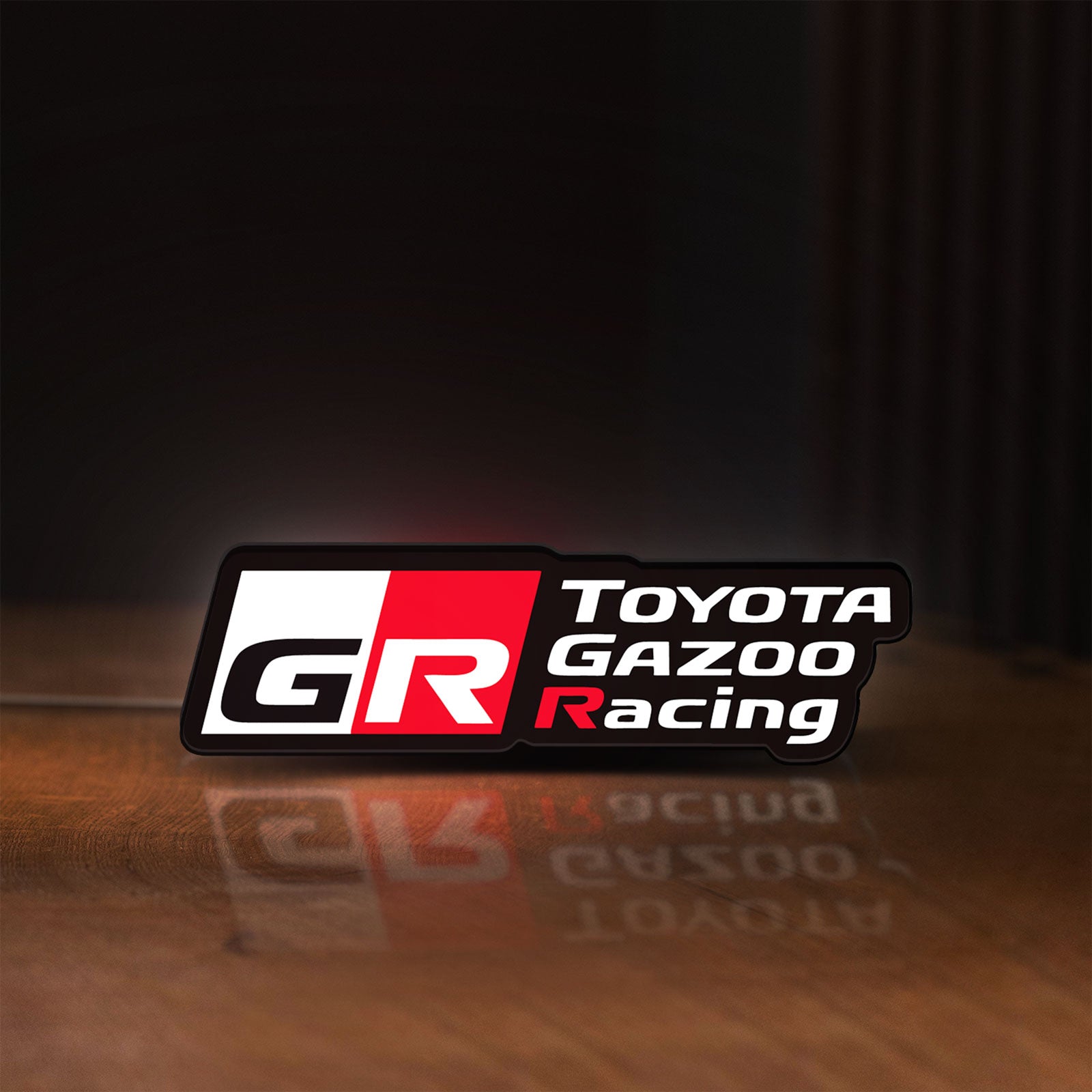 Front view of Toyota Gazoo Racing LED lightbox sign glowing on a wooden desk