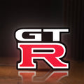 Front view of GT-R LED lightbox sign glowing on a wooden desk