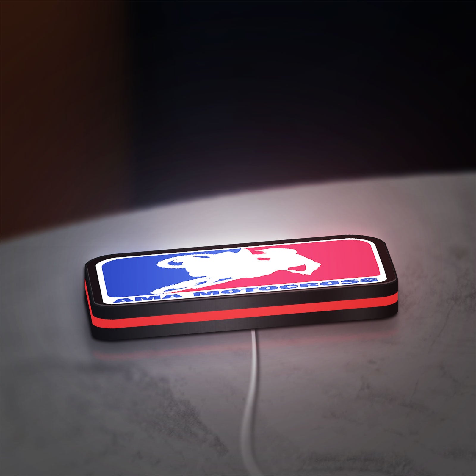 AMA Motocross LED lightbox lying flat on a desk with red glow