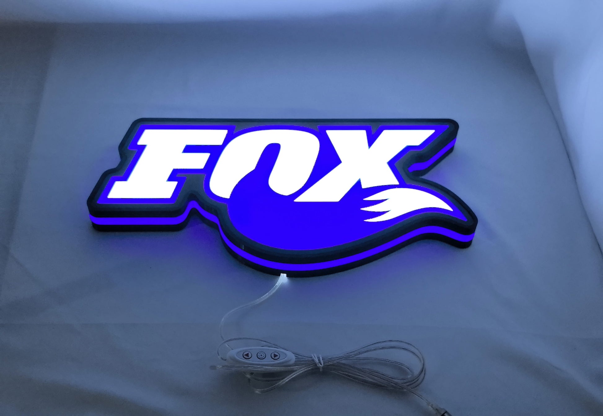 Illuminated flat lay angled view of Fox Racing Shox 3D LED Sign in 40cm, perfect for garage and man cave decor