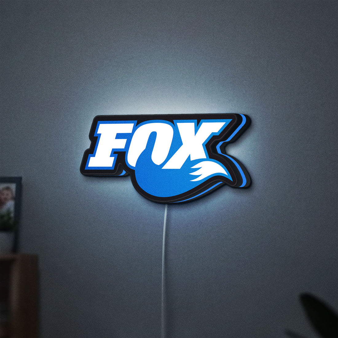 Fox Racing Shox LED lightbox hanging on a wall with blue glow