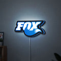 Fox Racing Shox LED lightbox hanging on a wall with blue glow