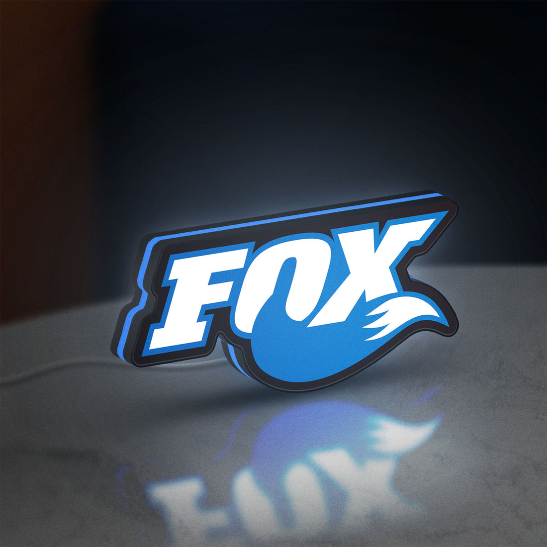 Fox Racing Shox LED lightbox hanging on a wall with blue glow