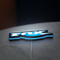 Fox Racing Shox LED lightbox lying flat on a desk with blue glow