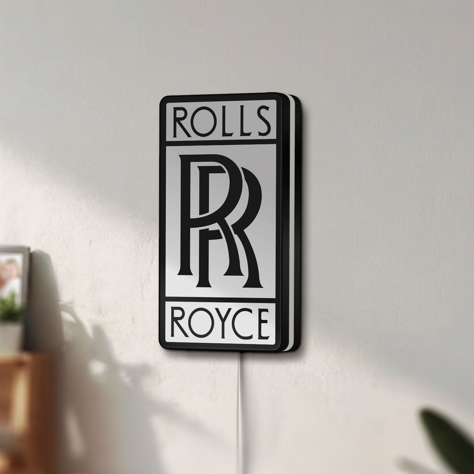 Unlit Rolls-Royce LED lightbox mounted on a wall in daylight
