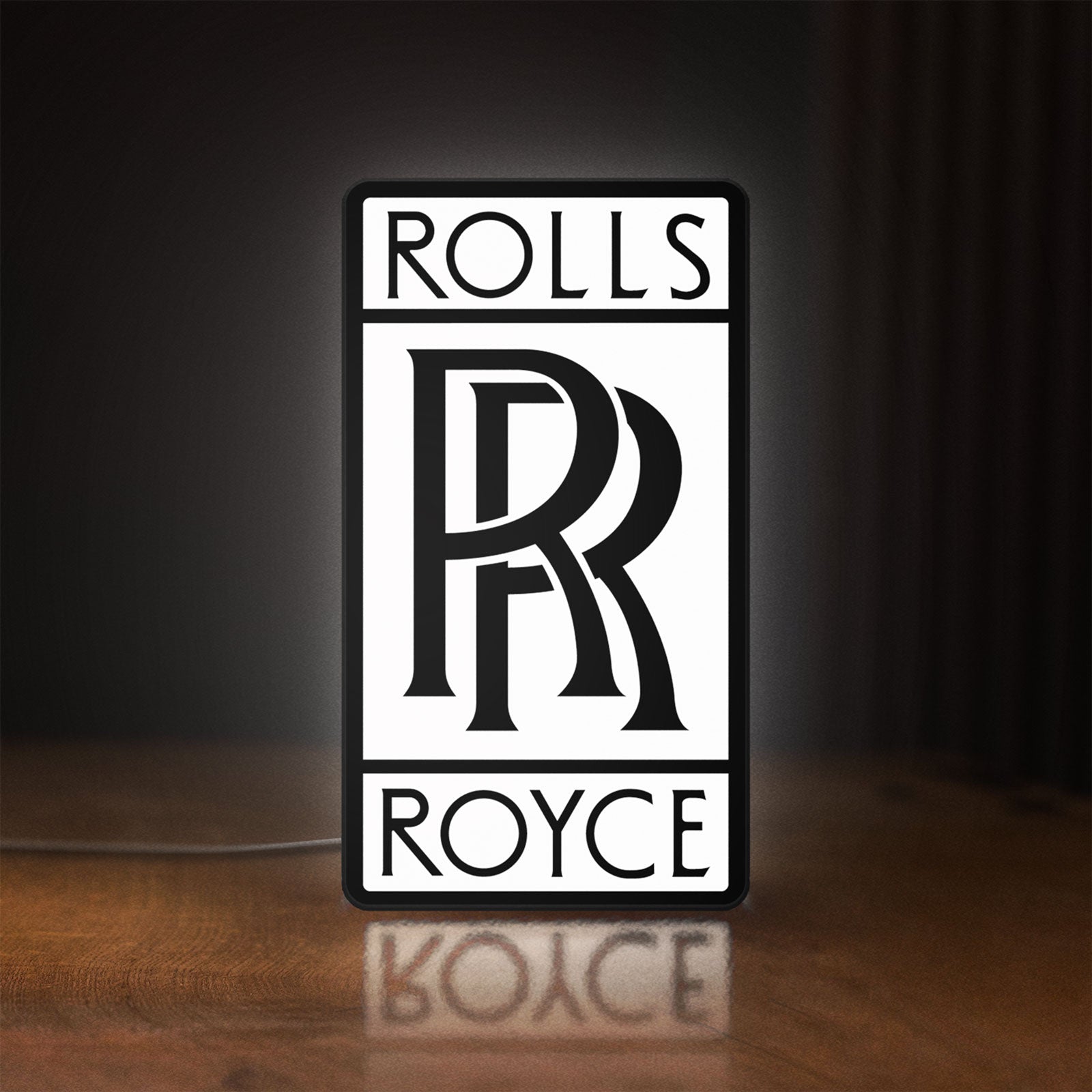 Front view of Rolls-Royce LED lightbox sign glowing on a wooden desk