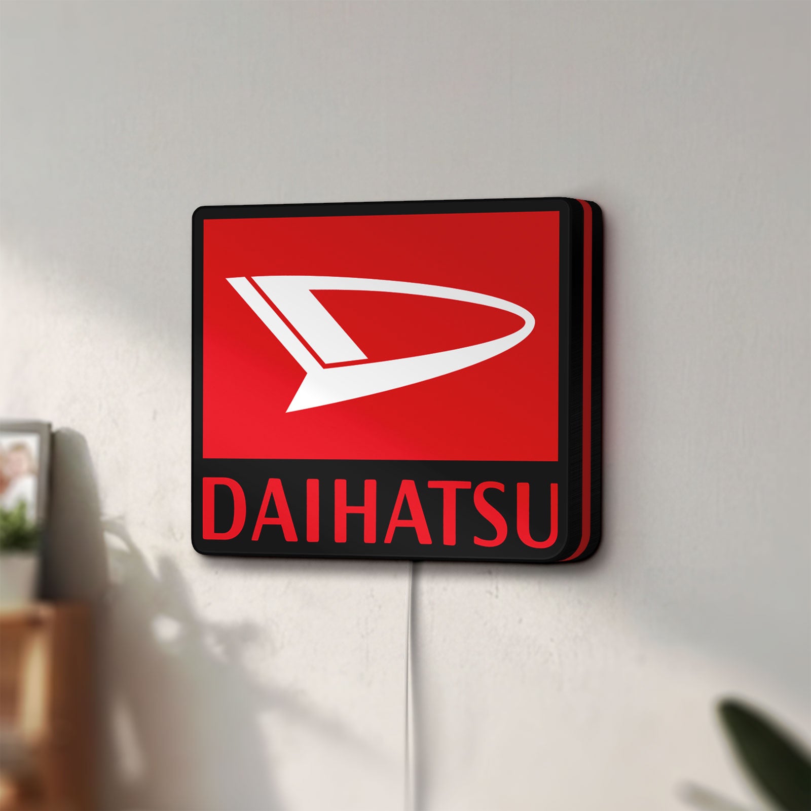 Unlit Daihatsu LED lightbox mounted on a wall in daylight