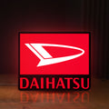 Front view of Daihatsu LED lightbox sign glowing on a wooden desk