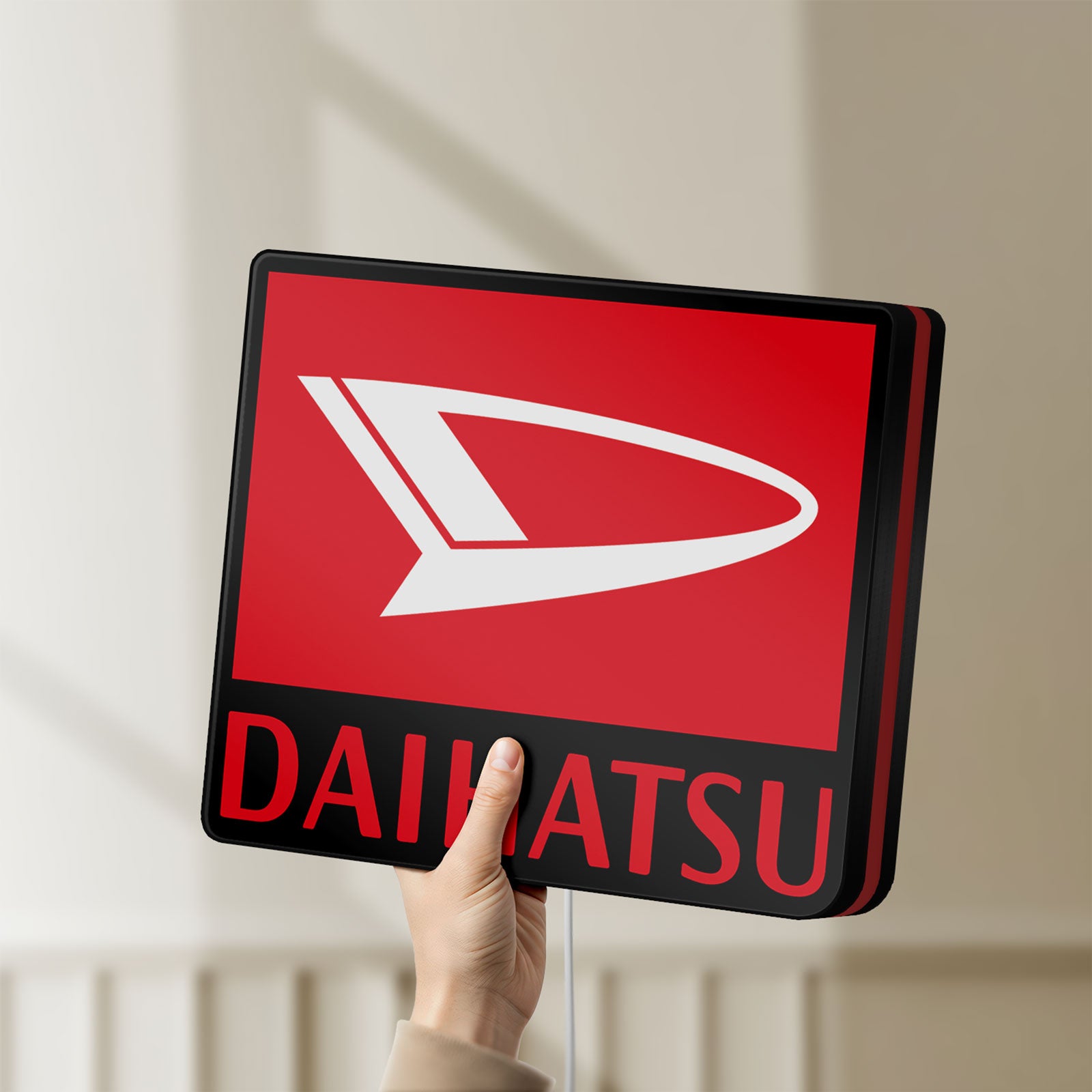 Unlit Daihatsu LED lightbox held by hand to show size and details