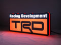 Illuminated angled view standing of Trd Racing Development Illuminated Sign in 30cm, perfect for garage and man cave decor