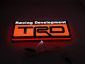 30cm Trd Racing Development Glowing Wall Art - Illuminated flat lay angled view, perfect for garage and man cave decor