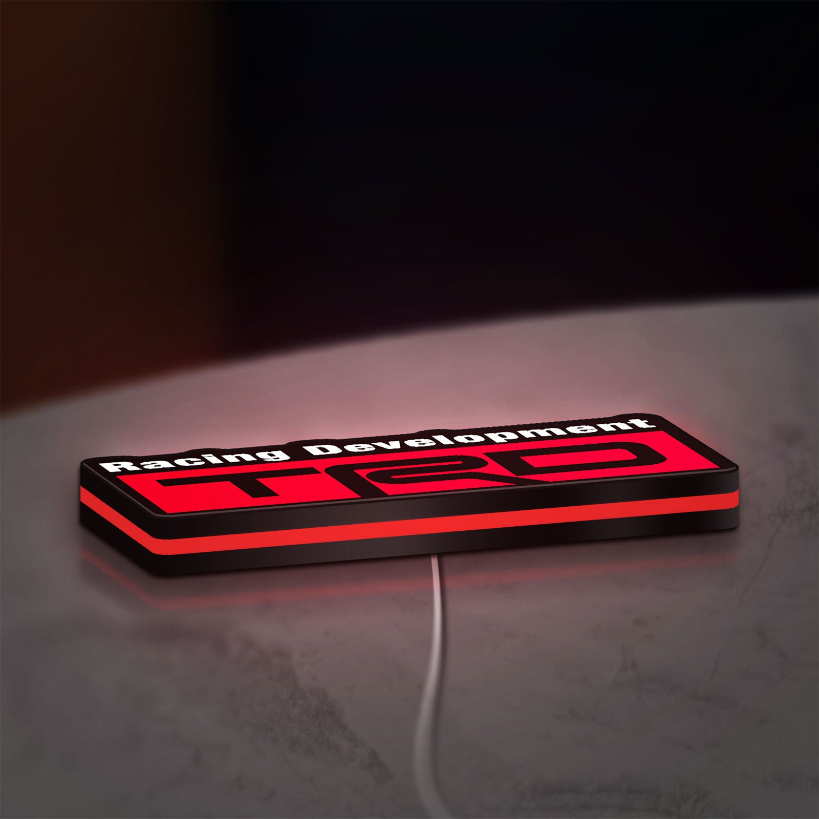 TRD Racing Development LED lightbox lying flat on a desk with red glow