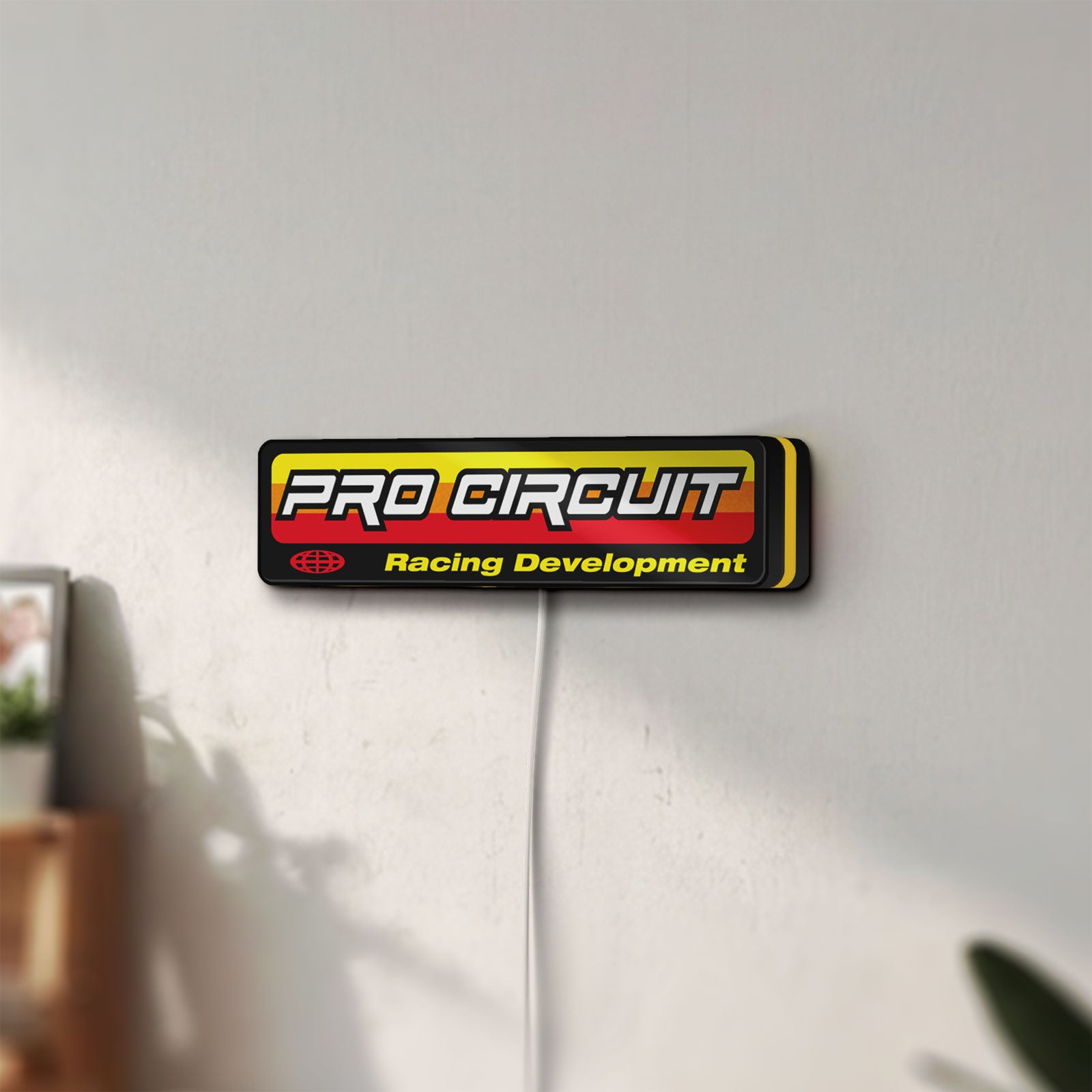 Unlit Pro Circuit Racing Development LED lightbox mounted on a wall in daylight
