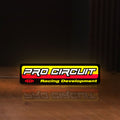 Front view of Pro Circuit Racing Development LED lightbox sign glowing on a wooden desk