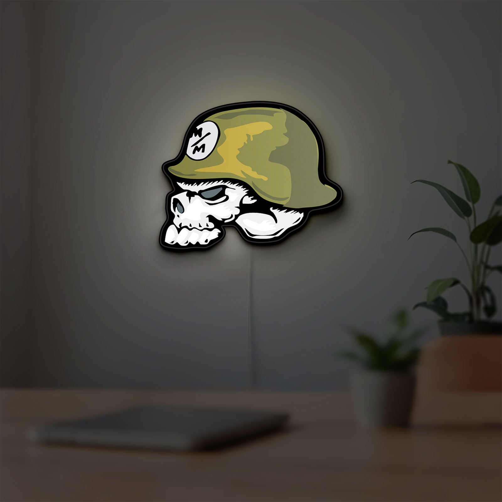 Metal Mulisha Skull LED lightbox hanging on a room wall with soft green light