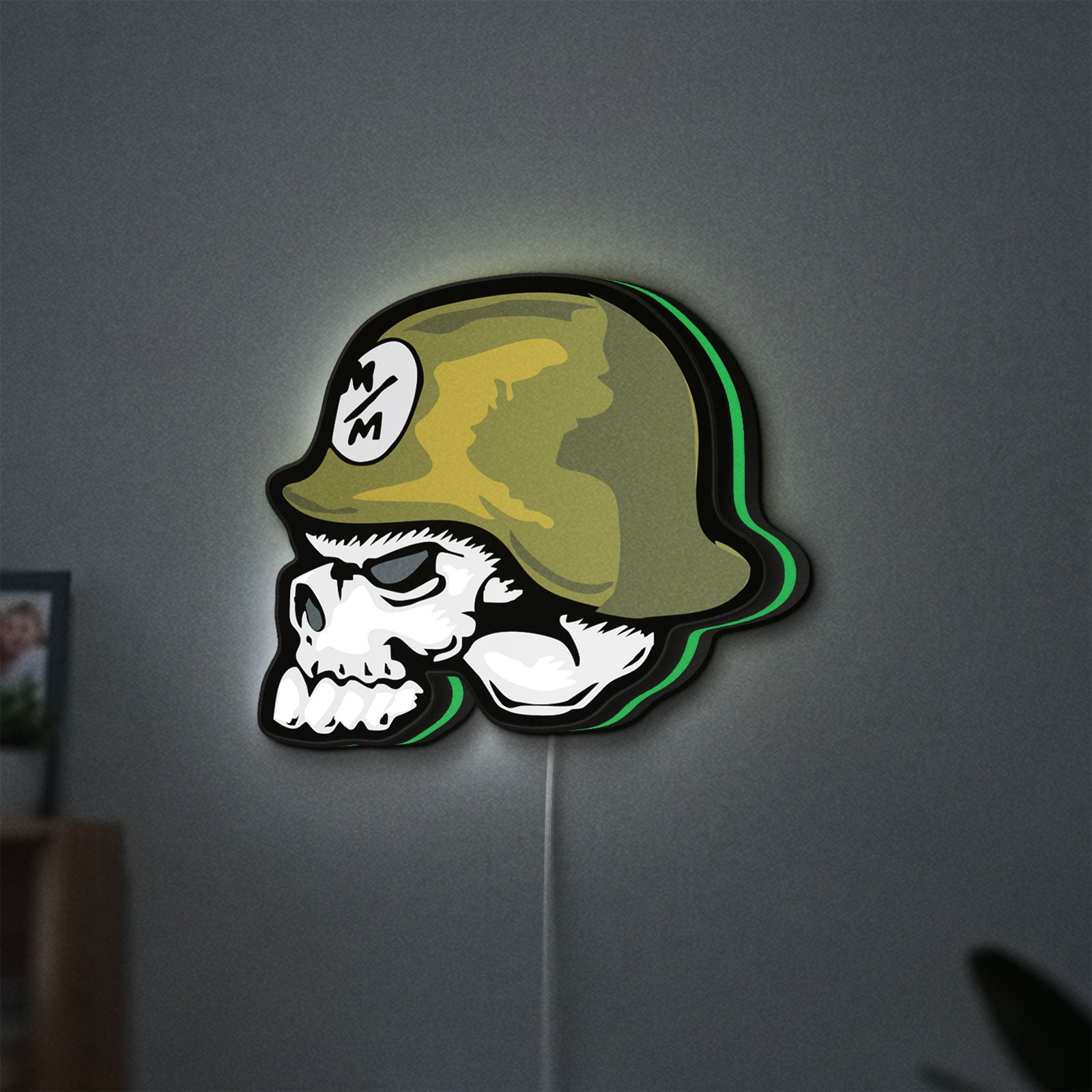 Metal Mulisha Skull LED lightbox hanging on a wall with green glow
