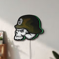 Unlit Metal Mulisha Skull LED lightbox mounted on a wall in daylight
